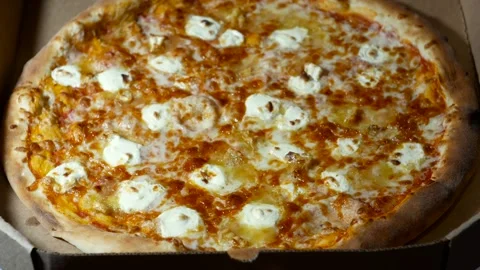 The hand opens a box with a "4 cheese" pizza inside. Stock Footage 272457370