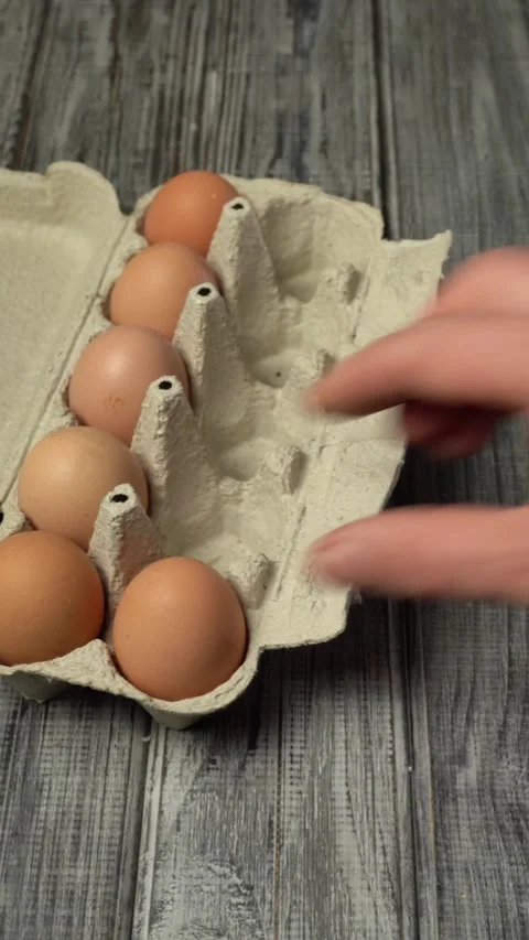 Hand opens box to fold eggs. Process of preparing to make egg dish for breakfast Stock Footage 330251131