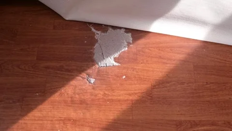A hand opens the carpet, revealing torn linoleum and a hole in the floor Vidéo 337101477