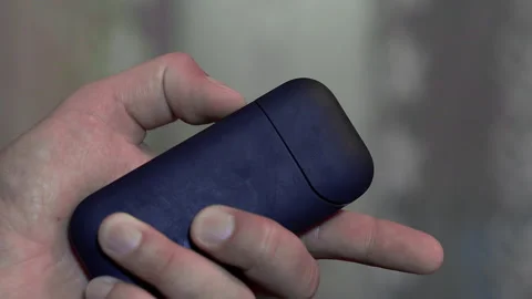 A hand opens the charging case of an electronic cigarette. Close-up Stock Footage 141145447
