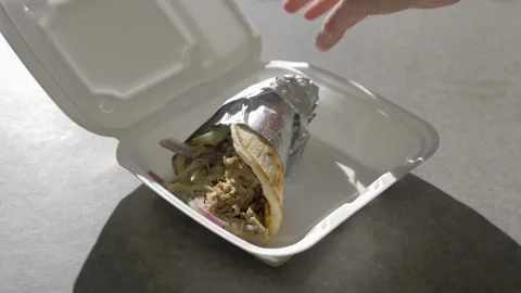 Hand opens container and takes out Gyro sandwich Stock Footage 276447480