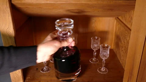 Hand opens cupboard and removes an alcohol decanter and glass. Vídeos de archivo 67478063