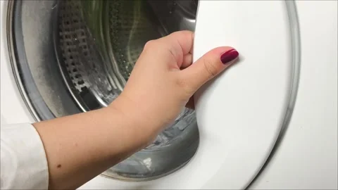 A hand opens the door of the washing machine, clean linen is inside Stock Footage 311992778