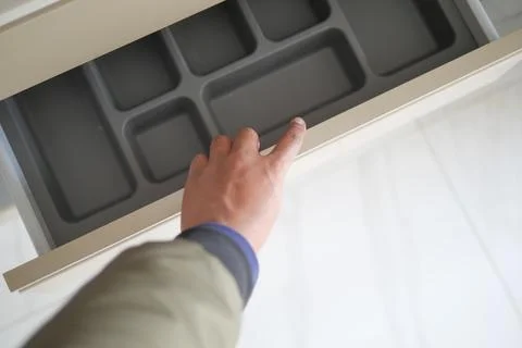 Hand opens drawer with empty organizing tray to maintain neat order in the space Stock Photos