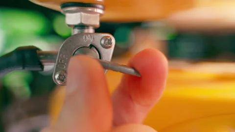The hand opens the fuel supply valve from the tank to the engine carburetor Stock Footage 208841246