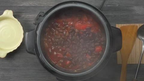 Hand opens lid of instant pot, beef, chili and beans simmer together Stock Footage 312469521