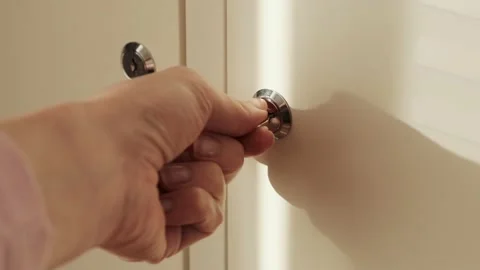 A hand opens the lock of an iron box or door with a key in white shelf Video stock 142508983
