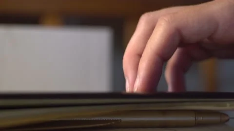 Hand opens a notebook and takes a pen in the form of a golden feather Stock Footage 138728226