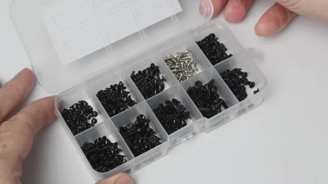 A hand opens an organizer of M2 screws for electronics, computer repair and Stock Footage 346876543