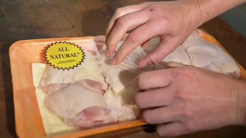 Hand opens package of raw chicken thighs Stock Footage 164006263