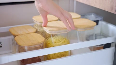 Hand opens pull out kitchen drawer, removes container and slides drawer closed Stock Footage 346492915