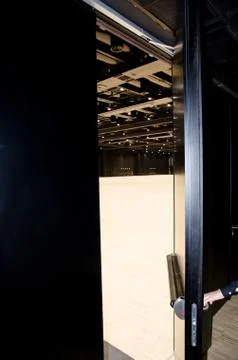 A hand opens a security door on a large hall in an industrial building. Stock Photos