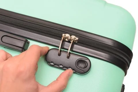 Hand opens suitcase combination lock on the suitcase. Stock Photos