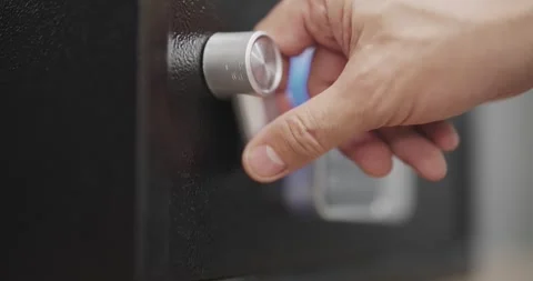 Hand opens a touchpad digital safe with a keypad sitting on a black surface.  Stock Footage 294972043