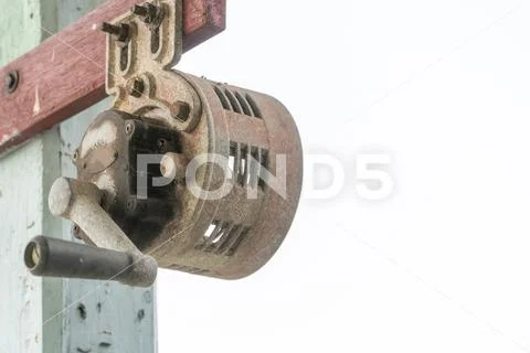 Hand operated siren old and rusty stick with wooden pole. Stock Photos