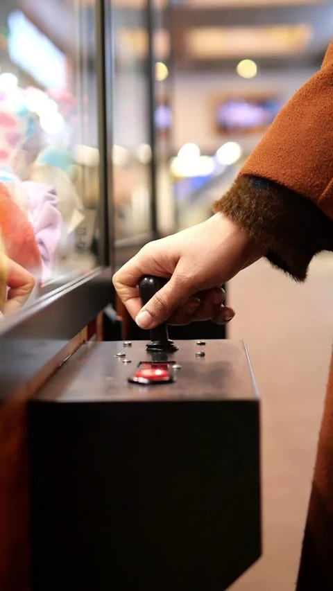 Hand operates claw machine in arcade with colorful prizes Stock Footage 336355039
