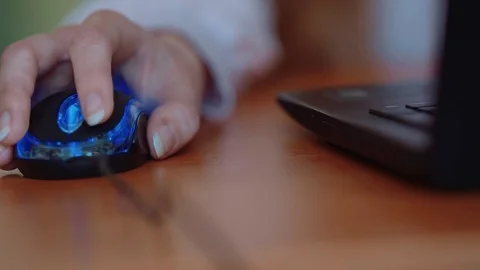Hand operates the mouse next to a laptop Stock Footage 72618190