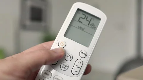 Hand operating air conditioning remote control Stock Footage 235550590