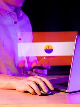 Hand operating computer with projected Paraguay flag hologram nearby 写真素材