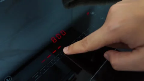 Hand operating modern induction stove touch panel, adjusting cooking temperature Stock Footage 345515827