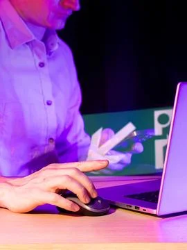 Hand operating mouse with scissors icon hologram on computer screen in viol.. Stock Photos