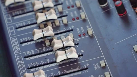 Hand operating professional audio mixer close up, colorful knobs and faders, Stock Footage 344011570