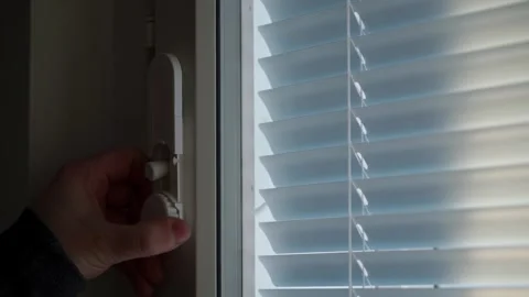 Hand operating window blinds in close up Stock Footage 326809971