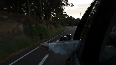 Hand out the window while driving at sunset Stock Footage 235662985