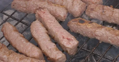 Hand overturns roasted meat at the grill Video stock 62802194