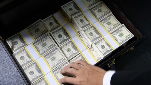 A hand packing of 100 dollar bills in a briefcase Stock Footage 126960925