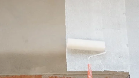 Hand with Paint Roller Moves on the Wall. Roller Painting gray Wall with Whit Stock Footage 202831464