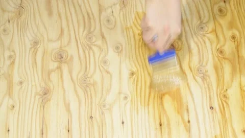Hand paint a wooden surface with clear varnish and a brush Stock Footage 217433499