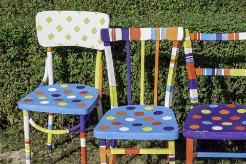 Hand painted chairs stand in the park.Different from other Stock Photos