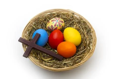 Hand Painted Christian Easter Eggs and Wooden Cross in Wicker Basket Stock Photos