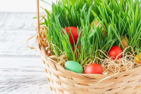 Hand-painted decorated Easter eggs in the basket on white wooden background.. Stock Photos
