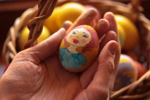 A hand-painted Easter egg in woman's hands. Preparation for Easter. Egg color Stock Photos
