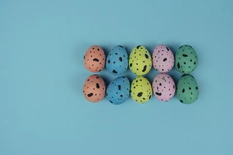 Hand painted Easter eggs isolated on blue background. Quail eggs. Happy Easter Stock Photos