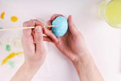 Hand painted Easter eggs, paints and brushes on a white table. Preparation fo Stock Photos