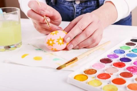 Hand painted Easter eggs, paints and brushes on a white table. Preparation fo Stock Photos