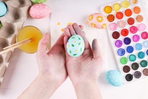 Hand painted Easter eggs, paints and brushes on a white table. Preparation fo Stock Photos