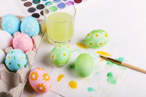 Hand painted Easter eggs, paints and brushes on a white table. Preparation fo Stock Photos