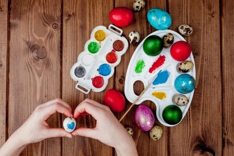 Hand painted Easter eggs, paints and brushes on wooden background. Preparatio Stock Photos