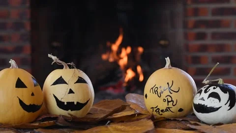 Hand painted Halloween pumpkins with a lit fireplace in the background Stock Footage 142093574