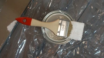 Hand of painter dipping a brush into a bucket with white paint , slow motion Stock Footage 86017704