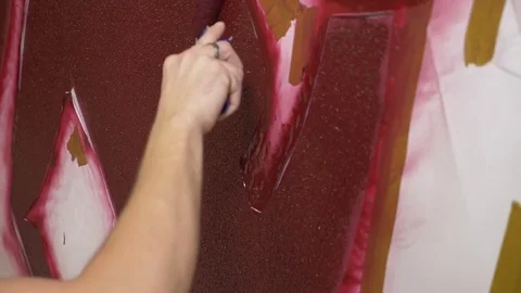 Hand painting the wall with paint roller on the stencil, close up. 4k Stock Footage 83833730