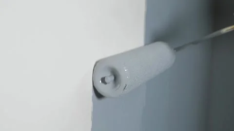 Hand painting wall with paint roller. Painting apartment, renovation with grey c Stock Footage 211380320