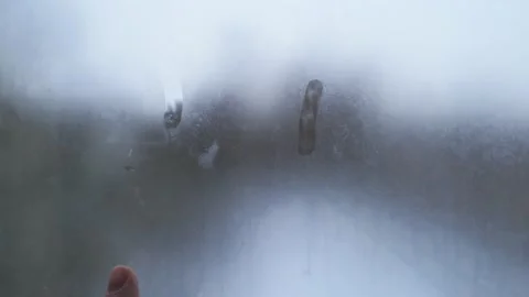 Hand paints a sad face on the misted glass. Symbol of loneliness and sadness Stock Footage 149072597