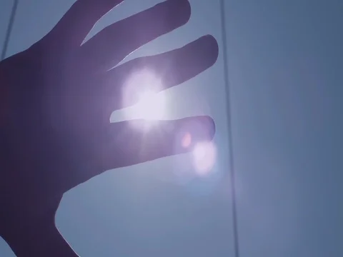 Hand Palm Sunshine Passing Through. Hand in silhouette raised up to the sun. Stock Footage 70725345