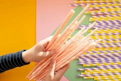 Hand with paper drinking straws .friendly biodegradable materials. Birthday p Stock-Fotos