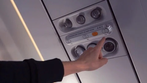 The Hand of the Passenger Turns On the Light on the Plane. Close-Up. Stock Footage 112141590